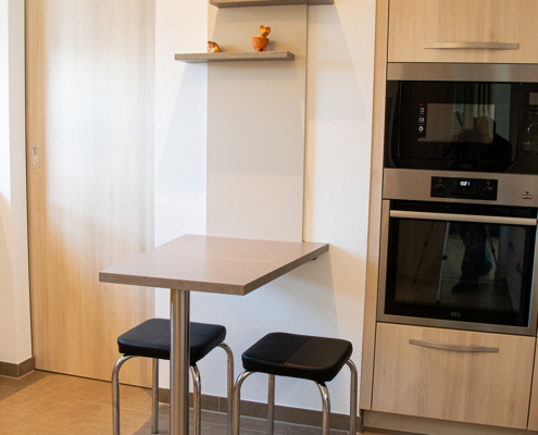 Moderne Küche mit hellen Holzfronten und Edelstahl-Griffen