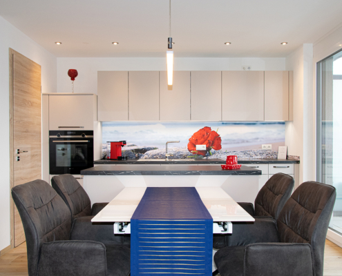 Moderne offene Wohnküche in Trendfarben mit Foto-Arbeitsplattenrückwand