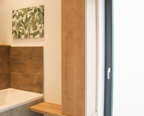 Hoher Badezimmerschrank mit grifflosen Türen bietet weiteren Stauraum